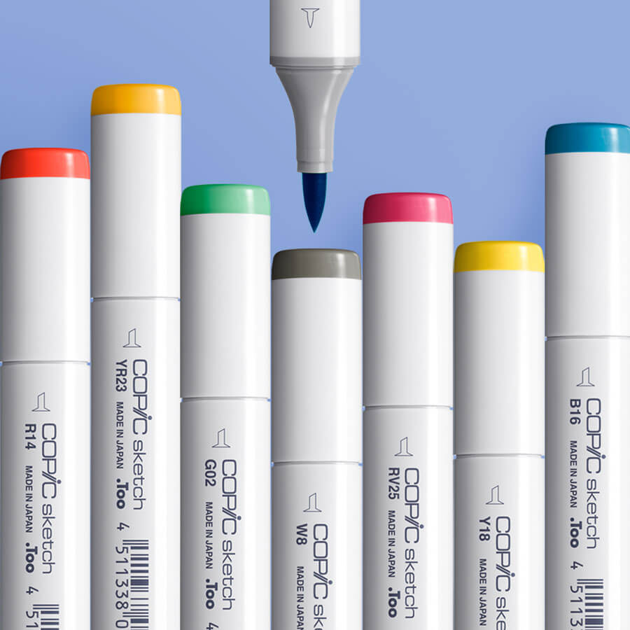 A close-up of COPIC Sketch markers with colourful caps and a brush nib against a blue background
